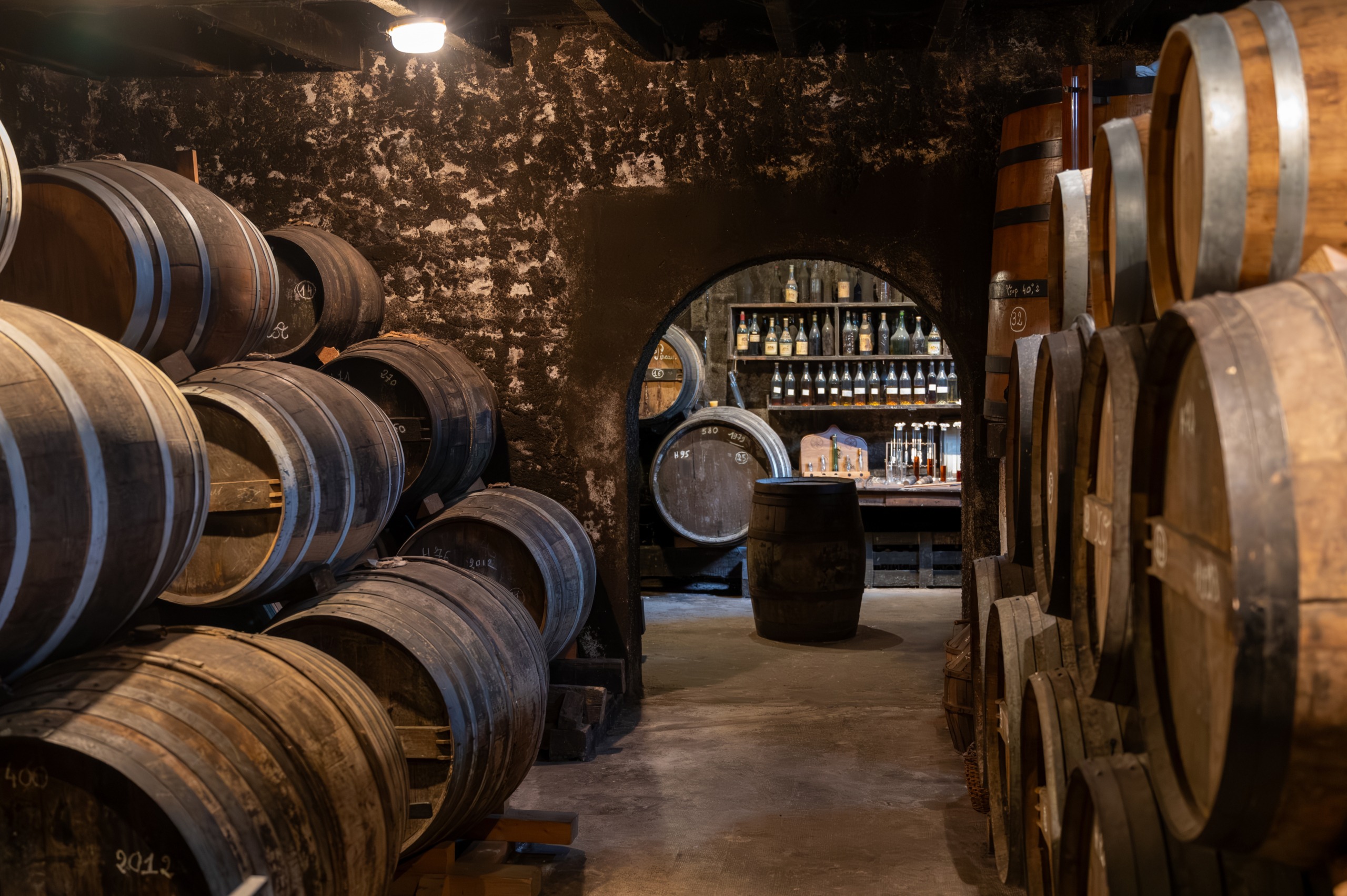 Aging process of cognac spirit in old French oak barrels in cell