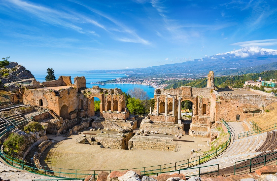Ancient Greek theatre in Taormina on background of Etna Volcano, Italy